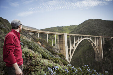 Männlicher Wanderer mit Blick auf die Bixby Creek Bridge - CAVF34833