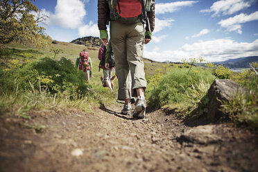 Rear view of hikers walking on hill - CAVF34844