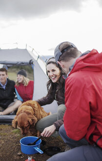 Glückliche Freunde mit Hund auf dem Campingplatz - CAVF34859