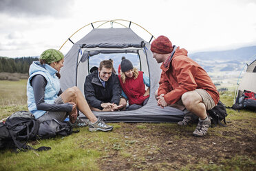 Friends camping on field against sky - CAVF34860
