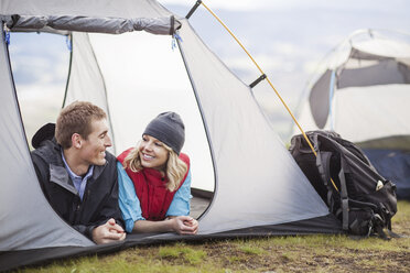 Glückliches Paar entspannt sich im Zelt auf dem Campingplatz - CAVF34863