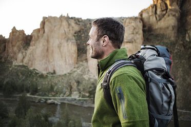 Happy man hiking by mountain - CAVF34869