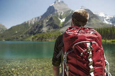 Männlicher Wanderer mit Rucksack im Glacier National Park - CAVF34912