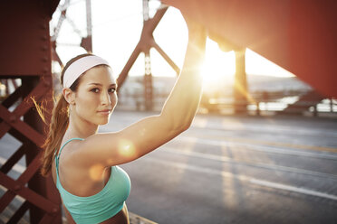 Porträt einer jungen Frau beim Sport auf einer Brücke - CAVF34950