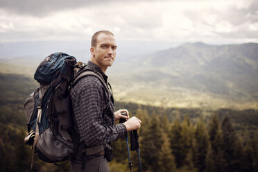 Portrait of male hiker carrying backpack while standing on mountain - CAVF34961