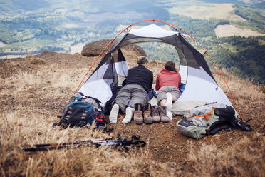 Couple lying in tent on mountain - CAVF34968