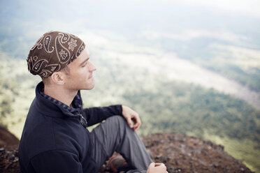 Mann meditiert auf einem Berg sitzend - CAVF34970