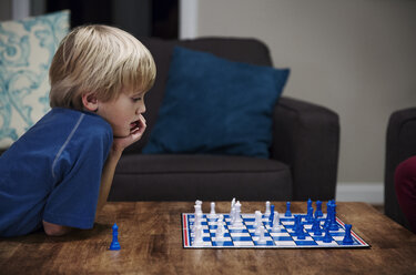 Blonder Junge spielt Schach am Tisch - CAVF35083