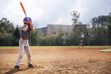 Seitenansicht eines Jungen, der einen Baseballschläger auf einem Feld schwingt - CAVF35131