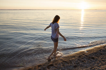 In voller Länge von Teenager-Mädchen zu Fuß am Strand bei Sonnenuntergang - CAVF35159