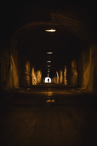 Norway, Lofoten Islands, Maervoll, silhouette of man in tunnel stock photo
