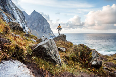 Norwegen, Lofoten-Inseln, Wanderer auf Felsen stehend - WVF01018