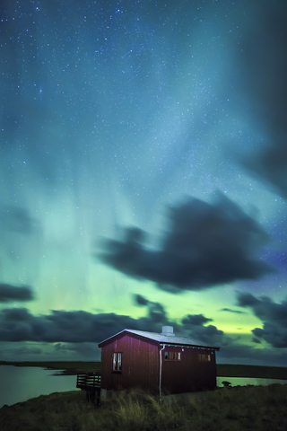 Norwegen, Lofoten, Eggum, Nordlicht und Holzhütte, lizenzfreies Stockfoto