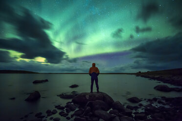 Norwegen, Lofoten-Inseln, Eggum, junger Mann bewundert Nordlicht - WVF01035