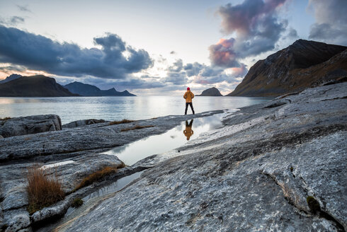 Norwegen, Lofoten-Inseln, Haukland Strand, Wanderer steht auf Felsen - WVF01036