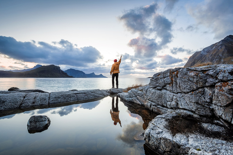 Norwegen, Lofoten-Inseln, Haukland Strand, Wanderer mit erhobenem Arm, lizenzfreies Stockfoto