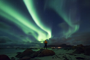 Norwegen, Lofoten-Inseln, Eggum, Mann bewundert Nordlicht - WVF01043