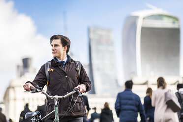 UK, London, Geschäftsmann schiebt Fahrrad in der Stadt - WPEF00158