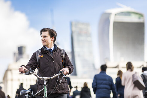 UK, London, businessman pushing bicycle in the city - WPEF00158