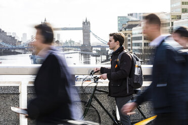 UK, London, Geschäftsmann schiebt Fahrrad in der Stadt - WPEF00160