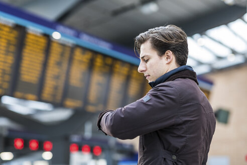 Großbritannien, London, Geschäftsmann auf dem Bahnhof, der die Zeit überprüft - WPEF00167