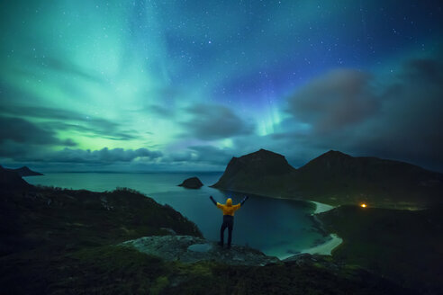 Norwegen, Lofoten-Inseln, Haukland Strand, Nordlicht, Mann mit erhobenen Armen - WVF01085