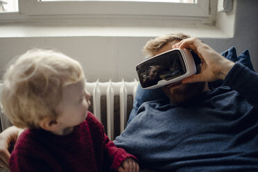 Vater und Sohn spielen mit VR-Brille zu Hause - KNSF03698