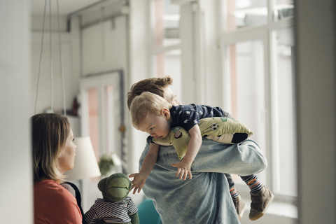 Happy family playing with their son at home stock photo