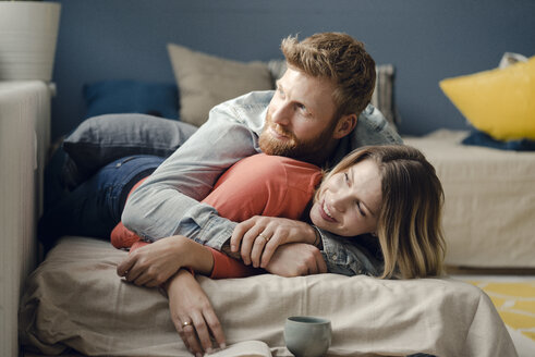 Affectionate couple cuddling at home - KNSF03726