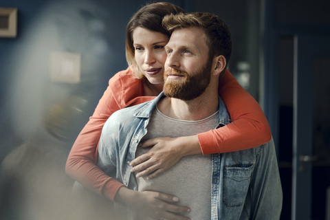 Glückliches Paar, das sich zu Hause umarmt, lizenzfreies Stockfoto