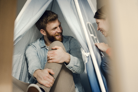 Glückliches Paar zu Hause beim Zelten im Wohnzimmer, lizenzfreies Stockfoto