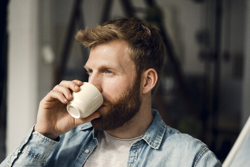 Man relaxing at home, drinking coffee - KNSF03737