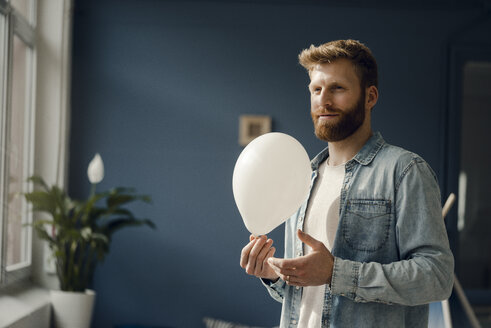 Man holding a balloon, smiling - KNSF03739