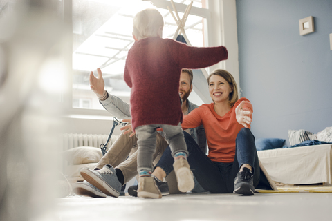 Glückliche Familie spielt mit ihrem Sohn zu Hause, lizenzfreies Stockfoto
