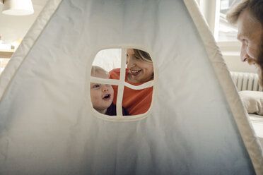 Glückliche Familie beim Spielen in einem Zelt zu Hause - KNSF03749