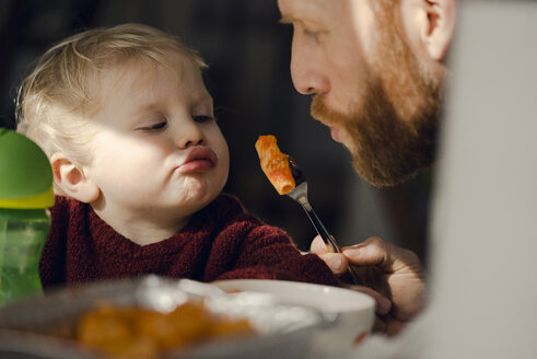 Father feeding his little son with tasty pasta - KNSF03752