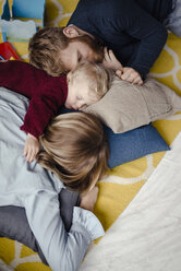 Tiered family resting together on the floor after playing - KNSF03765