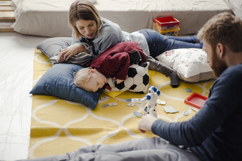 Glückliche Familie spielt mit ihrem Sohn zu Hause, lizenzfreies Stockfoto