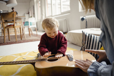 Kleiner Junge erkundet mit seiner Mutter eine Gitarre - KNSF03776