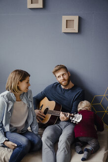 Happy family playing music with their son at home - KNSF03779