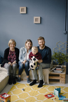 Family sitting in living room with son and grandmother - KNSF03781