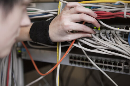 Woman pulling network cables - MASF00347