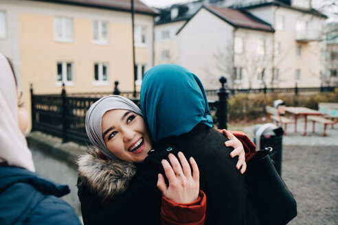 Glückliche junge Freundinnen umarmen sich in der Stadt - MASF00431