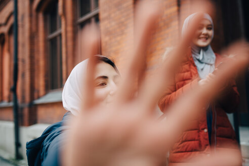 Nahaufnahme der Hand gegen weibliche Freunde in der Stadt - MASF00437