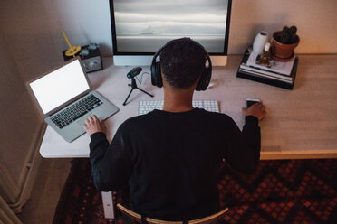 Hohe Winkel Ansicht der jungen freiberuflichen Arbeiter mit Laptop und Computer am Schreibtisch - MASF00452