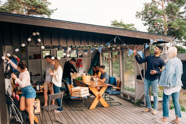 Junge männliche und weibliche Freunde bereiten sich auf eine Party in einer Hütte vor - MASF00660
