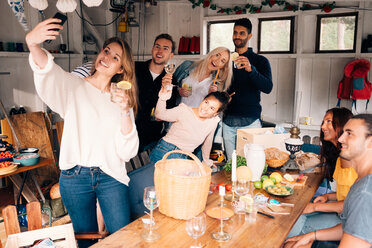 Young woman taking selfie with friends during lunch party - MASF00663