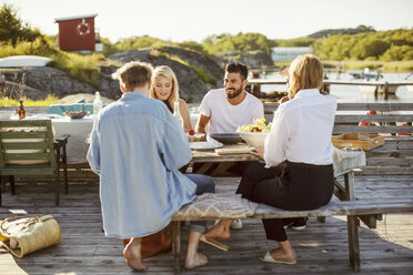 Junge multiethnische Freunde genießen ein sommerliches Mittagessen am Hafen - MASF00679