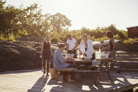 Junge multiethnische Freunde am Picknicktisch im Sommer, lizenzfreies Stockfoto