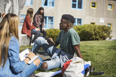 Junge Freunde studieren, während sich Universitätsfreunde auf dem Campus unterhalten - MASF00707